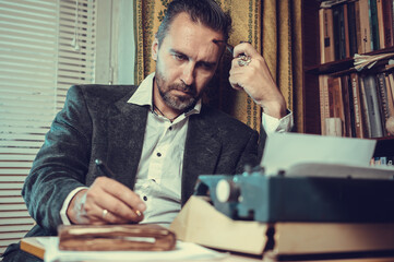 Vintage male writer reporter working behind his desk