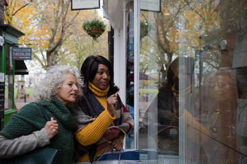 Senior women friends window shopping outside storefront