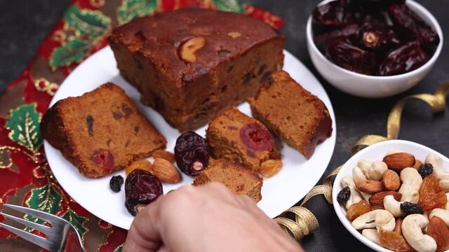 Homemade Christmas plum cake Indian Christmas celebration serving  India Kerala. 4K footage video Fruitcake made dried fruit, nuts, spices , rum for New Year party, Easter, Christmas Eve fruit cake 