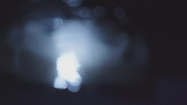 The Graphic material of the obscures bokeh taken with a macro lens of the light reflected by the ripples on the water surface in the gloom