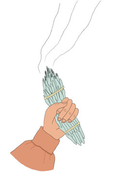 hand clutching a bundle of burning sage