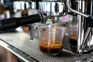 machine pouring coffee into a glass.