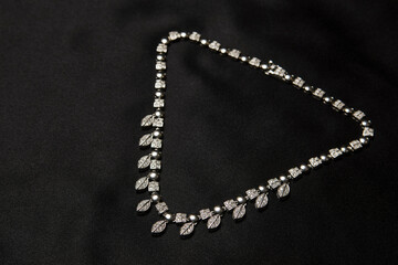 Necklace with diamonds on black background with copy space