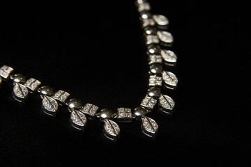 Necklace with diamonds on black background with copy space