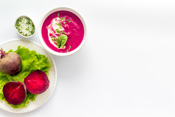 Beet soup with sour cream and fresh beet roots. Top view