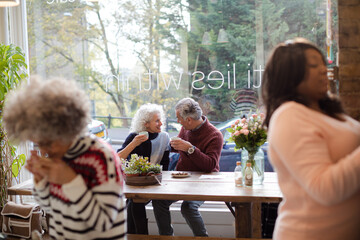 Smiling active senior couple enjoying coffee at  cafe