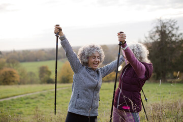 Portrait smiling, happy active senior women friends with walking sticks