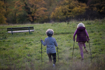 Smiling, affectionate senior women with walking sticks