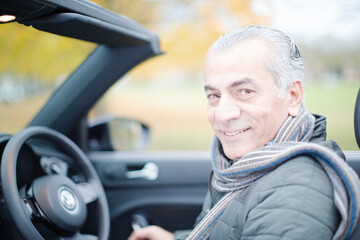 Smiling, affectionate senior man in car