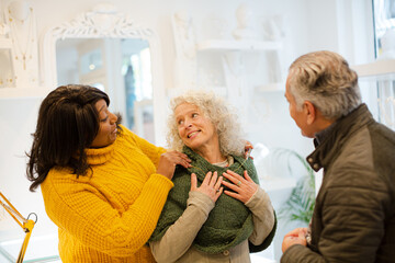 Sales assistant helping senior couple jewelry shopping