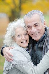 Portrait smiling, affectionate senior couple hugging in park