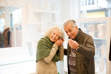 Smiling senior woman with husband in jewelry store