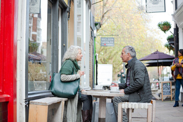 Senior couple drinking coffee at sidewalk cafe