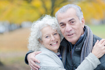 Portrait smiling, affectionate senior couple hugging in park