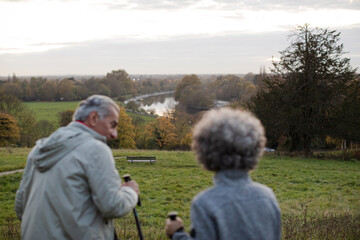 Affectionate senior couple wih walking sticks