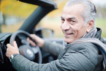 Smiling, affectionate senior man in car