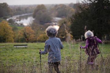 Smiling, affectionate senior women with walking sticks