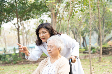 Doctor help and care Asian senior woman lady sitting on wheelchair in park.