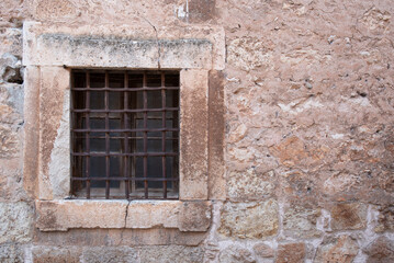 old window with bars, located in a medieval wall
