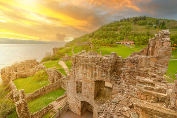 top view of Urquhart Castle at sunset beside Loch Ness in Scotland, United Kingdom. Close to...