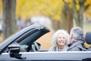 Smiling, affectionate senior couple talking in car