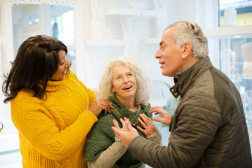 Sales assistant helping senior couple jewelry shopping