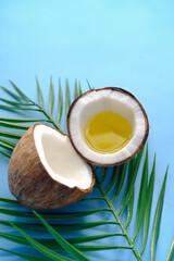 slice of fresh coconut and oil on blue background 
