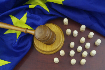 Court in European Union concept. Wooden figures as people, EU flag and judge gavel.
