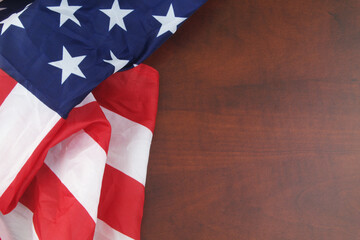USA flag on wooden table. Close up of waved United States flag with space for text.	