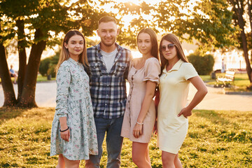Fototapeta premium Man with three women standing in the park and embracing