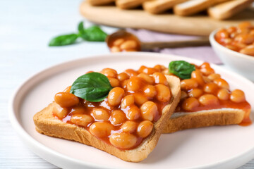 Toasts with delicious canned beans on white wooden table, closeup