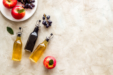 Apple cider and balsamic vinegar in bottles with grapes and red apples