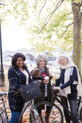 Portrait confident, smiling senior women bike riding in autumn park