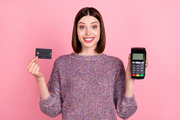 Photo of cheerful lady presenting debit card terminal reader wear knitted pullover isolated pink...