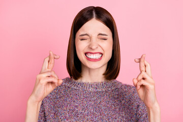 Photo of nervous frightened lady crossed fingers close eyes wear knitted sweater isolated pink...