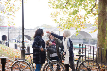 Obraz premium Enthusiastic senior women friends hugging in autumn park