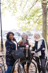 Portrait confident, smiling senior women bike riding in autumn park