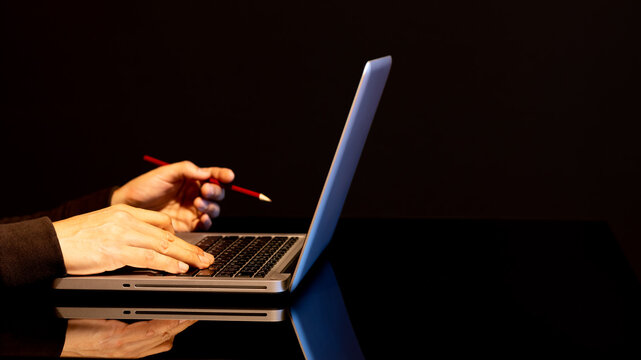 man using laptop computer for working, surfing website, browsing information on black background