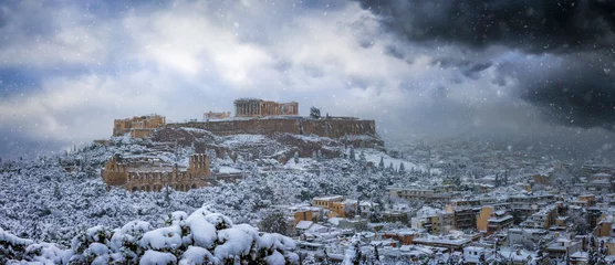 Rolgordijnen Panoramic view to the Parthenon Temple and the Acropolis of Athens, Greece, during winter time with thick snow and grey clouds © moofushi