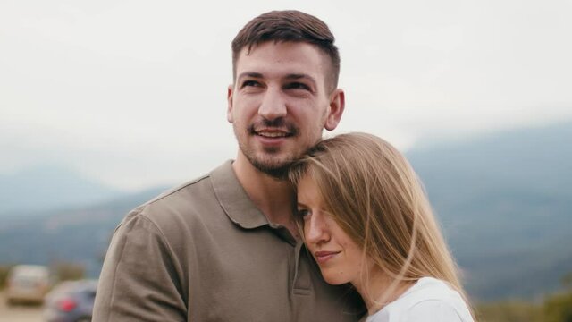 Young loving couple standing and hugging in mountains 