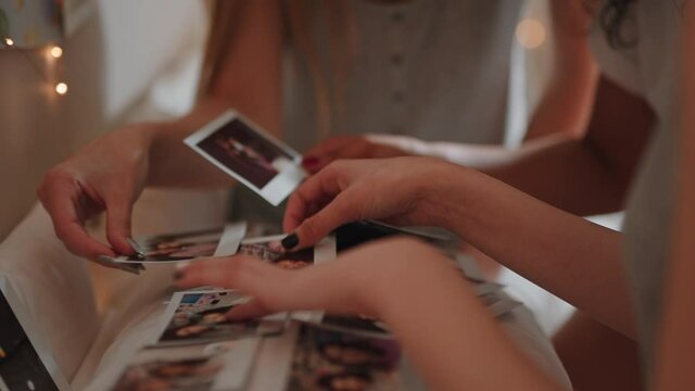 happy teen girls looking at photos at home having fun sharing memories hanging out together