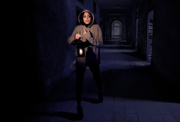 Scared woman in haunted house at night whit candle lamp in Halloween