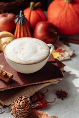 Obraz na płótnie Canvas autumn layout . a mug of coffee, a pumpkin, apples and spices are lying near the book