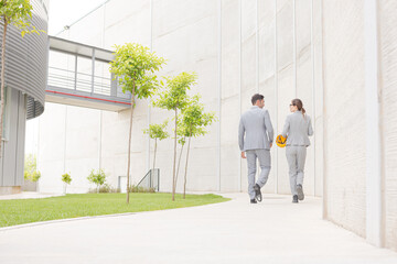 Supervisors walking on sidewalk below building