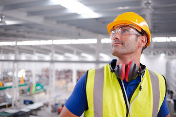 Portrait serious male worker in protective eyewear and hard-hat in factory - obrazy, fototapety, plakaty