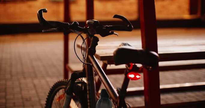 Empty bicycle with flashing front and back lighting on dark city street. Sport bicycle with night lighting parking on empty night street