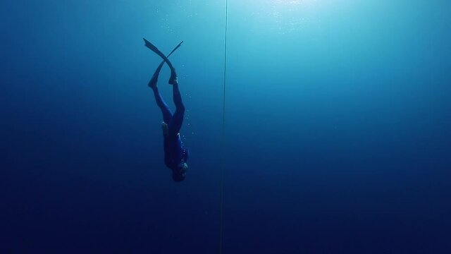 Freediving in the Red Sea. Male freediver descends along the rope with bifins during training dive in the Red Sea in Egypt