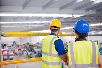 Supervisor and worker talking in steel factory