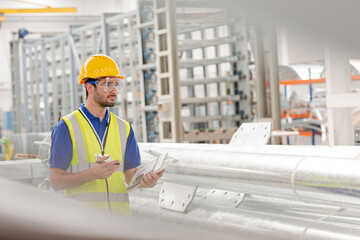 Male worker using digital tablet in steel factory