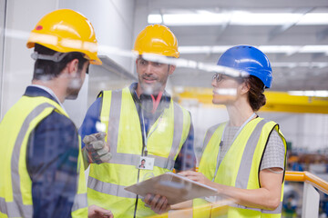 Supervisors and worker with clipboard talking in factory